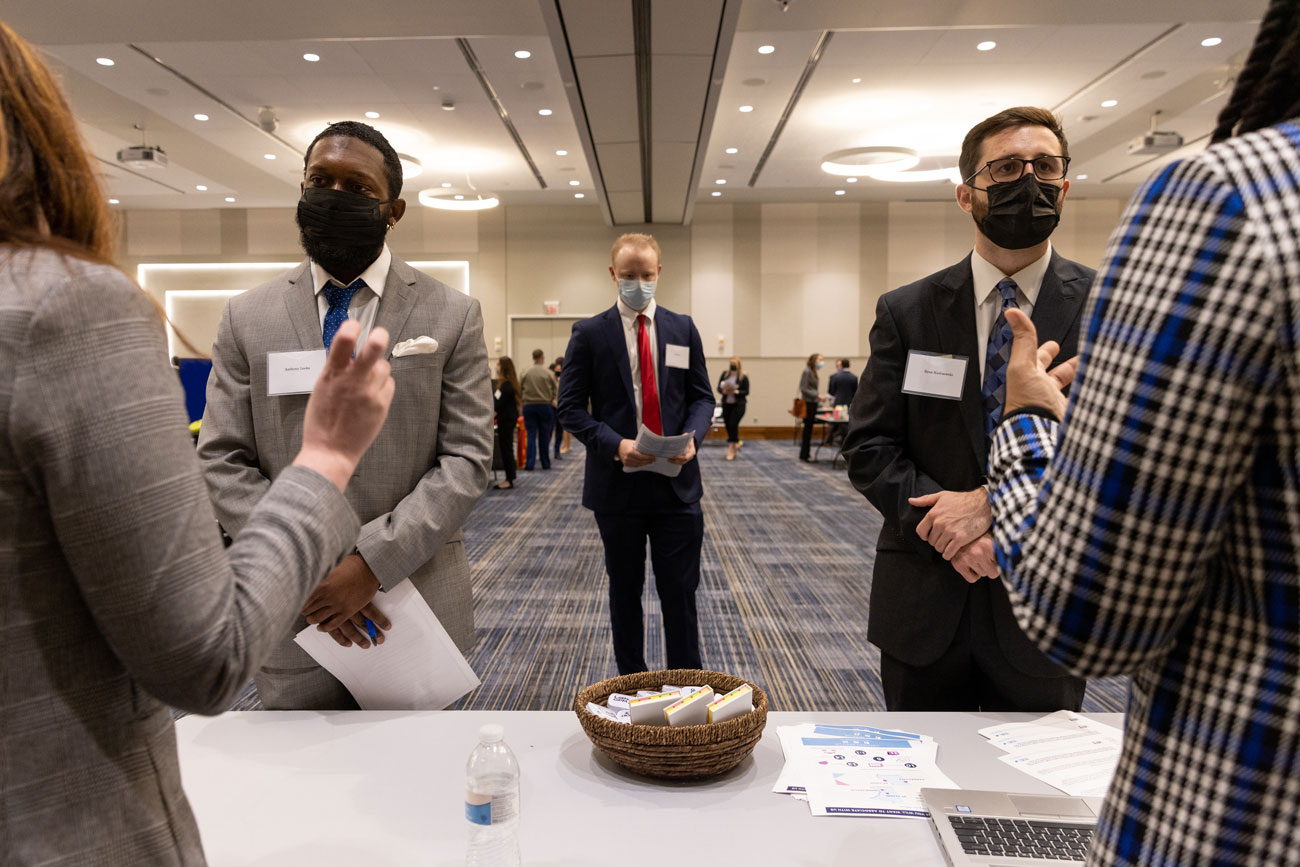 Two students talk with employers during a career fair
