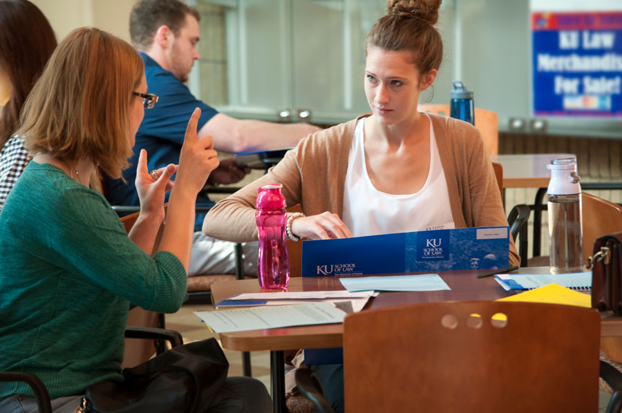 A student meets with a professor for an advising appointment in the law school commons