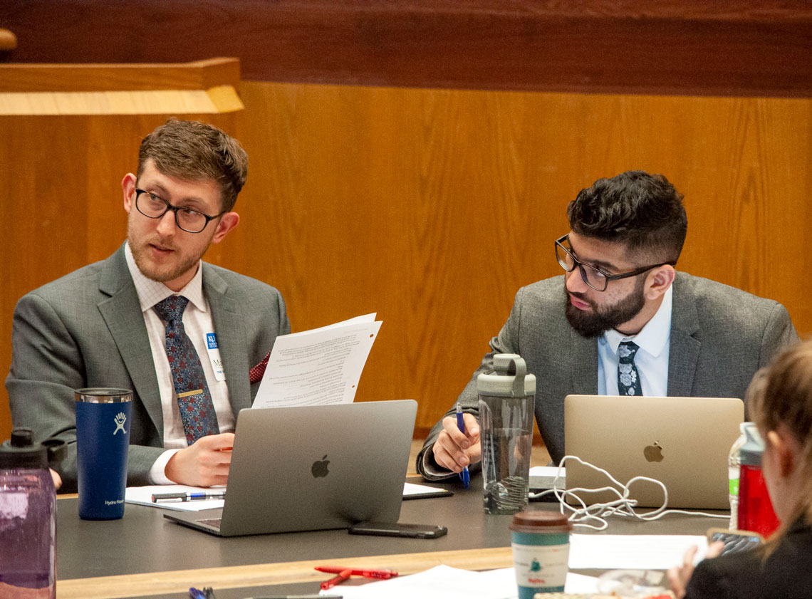 Two students talk at a table during a skills course