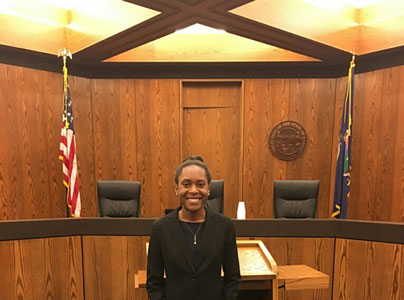 Malika Baker stands in a courtroom