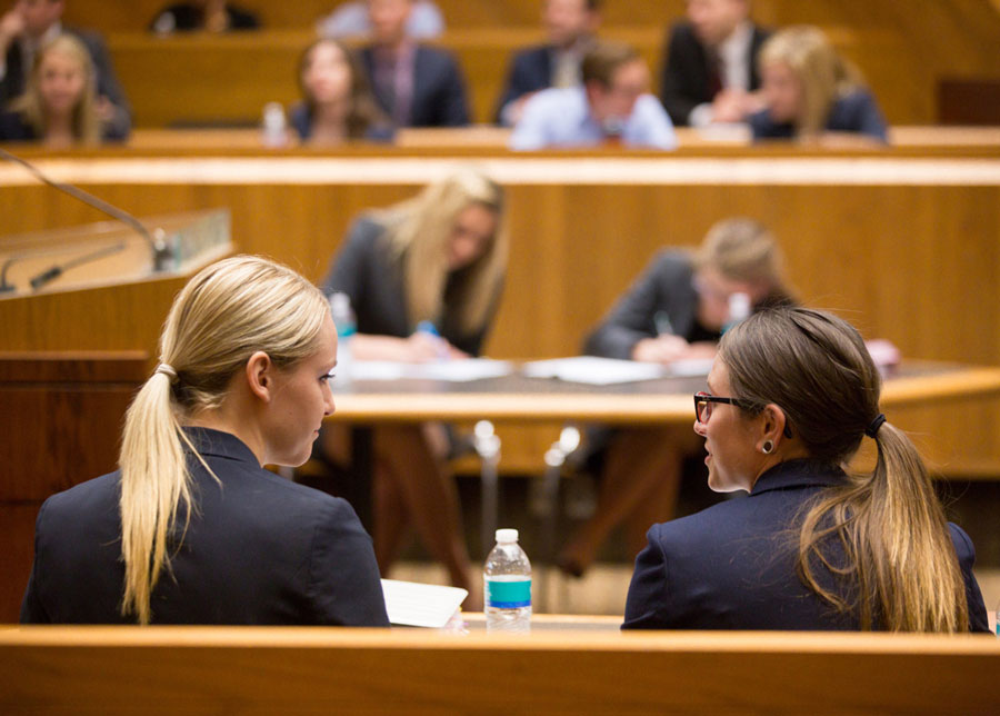 Two students discuss a case during a moot court competition in the KU Law courtroom