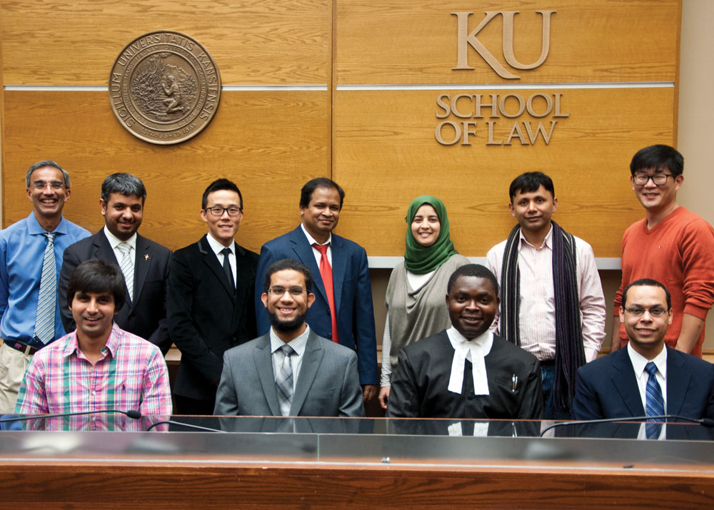 A group of international students poses in the courtroom at KU Law