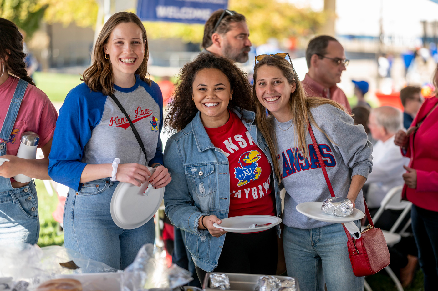 A group of students pose at a Homecoming tailgate
