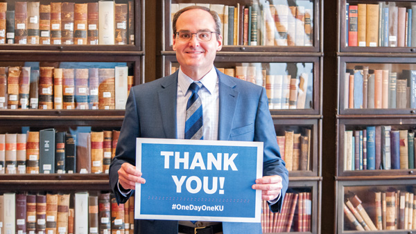 Dean Mazza holds a sign reading "thank you" inside the Rice Room at Green Hall