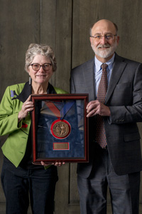 Doug Bonney, right, accepts a KU Law Medallion with Rochelle Harris, left.