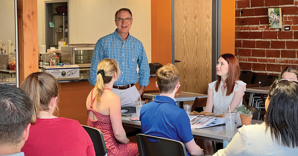 Jere Sellers, standing at center, speaks with summer associates about pro bono work in the Marlborough neighborhood