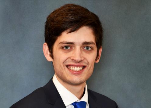 A headshot of Chris Carey in front of a blue backdrop. 